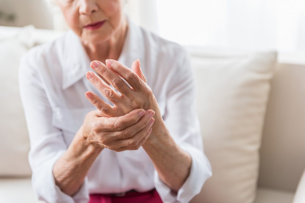 starší žena držící svoji revmatickou ruku